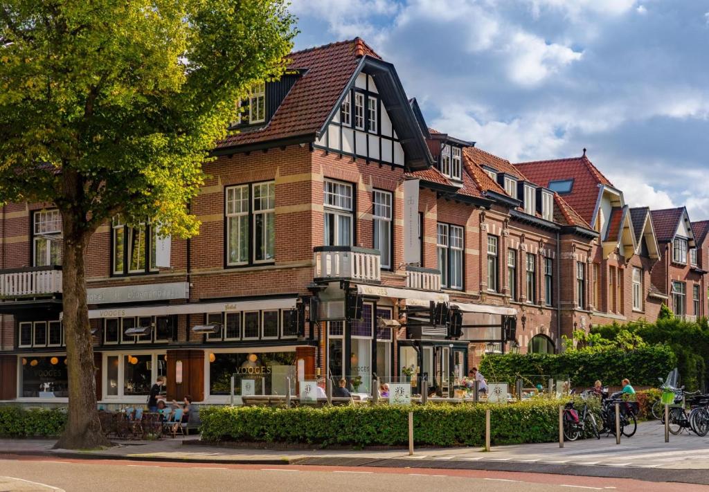 a group of buildings on a street with a tree at Hotel Bloemendaal in Bloemendaal