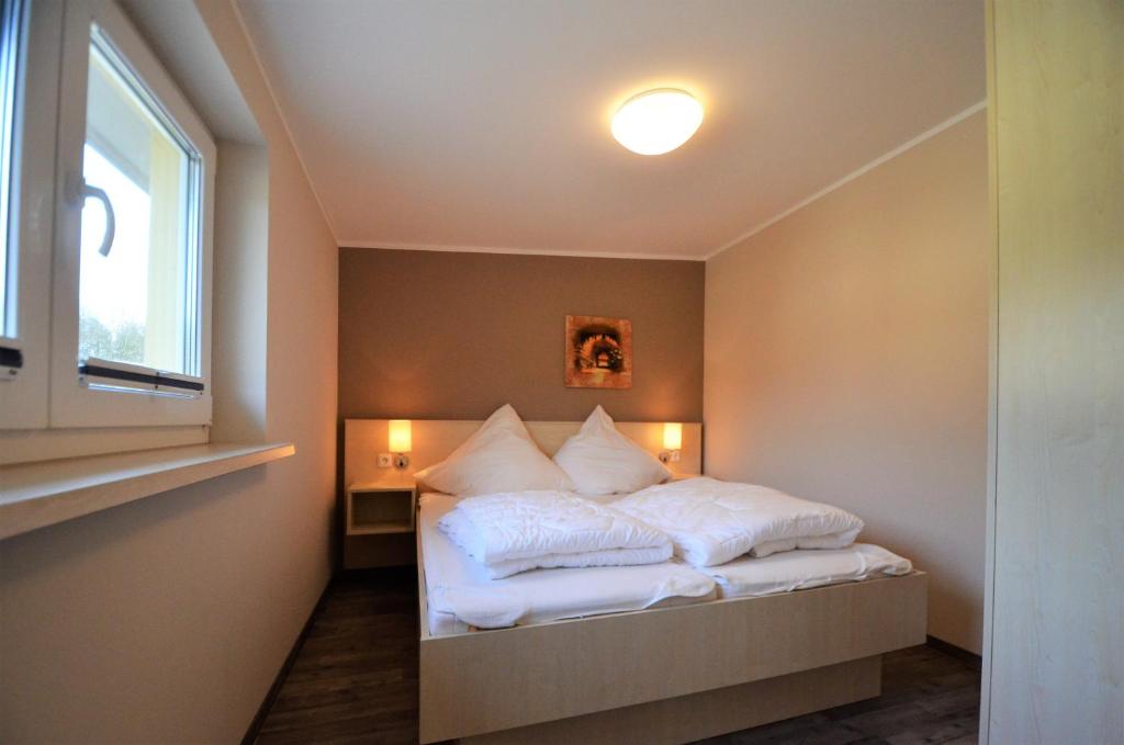 グラール・ミューリッツにあるFerienwohnungen Graal-Müritzのベッドルーム1室(白いシーツ付きのベッド1台、窓付)