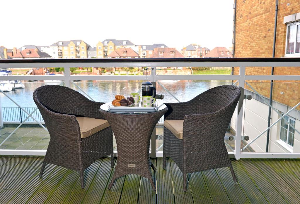een balkon met 2 stoelen en een tafel met eten bij Pacific Heights in Eastbourne