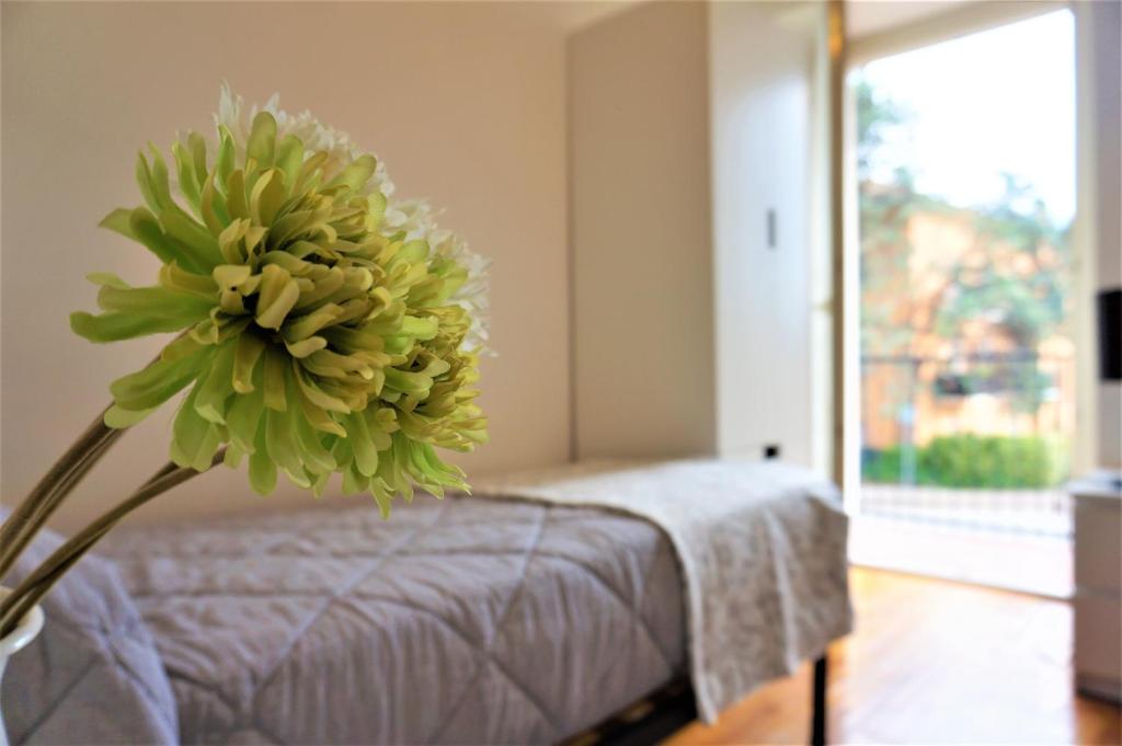 een grote groene bloem in een kamer met een bed bij Apartment La Coccinella in Riva del Garda