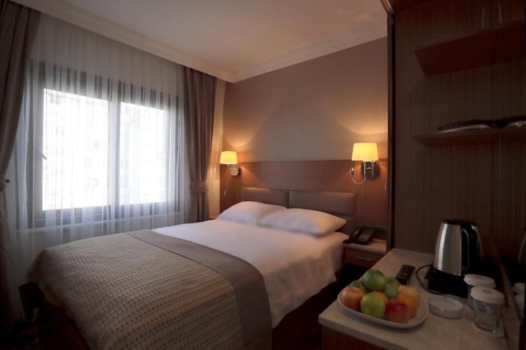 una habitación de hotel con una cama y un bol de fruta en NL Amsterdam Hotel, en Estambul
