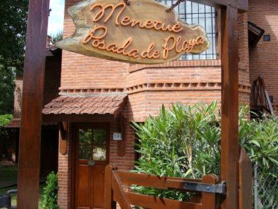 un restaurante con un cartel en la parte delantera de un edificio en Menetué Posada de Playa en Valeria del Mar