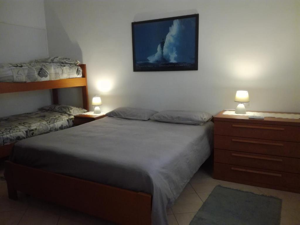 a bedroom with two beds and two night stands with lamps at Casa Gemma in Diano Marina