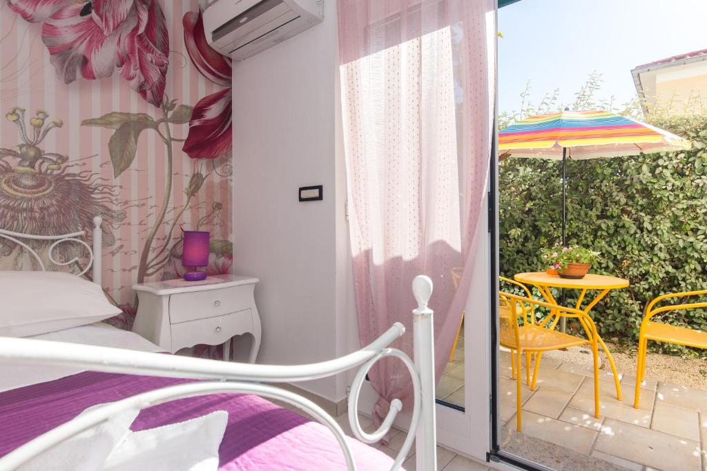 1 dormitorio con 1 cama y 1 mesa con sombrilla en Apartments & rooms DDD2, en Baška