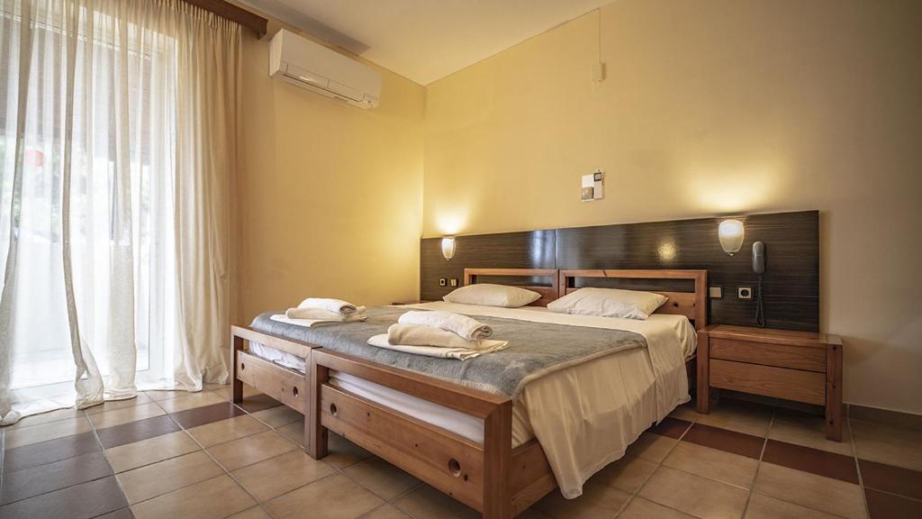 a bedroom with a large bed and a large window at Thea Hotel in Possidi
