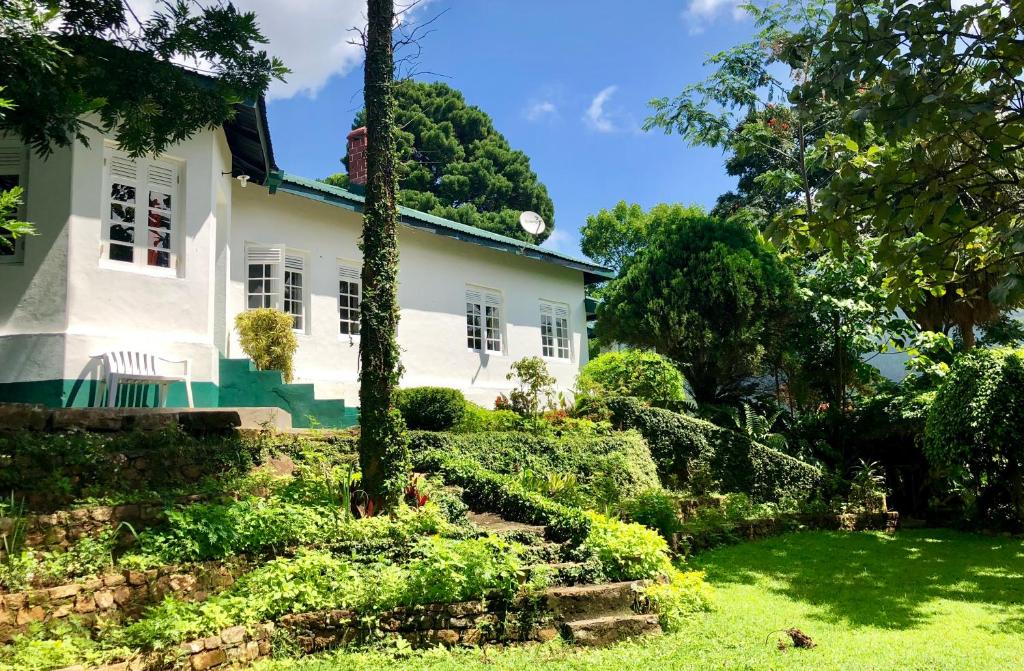 a white house with a garden in front of it at Gammaduwa Bungalow in Matale