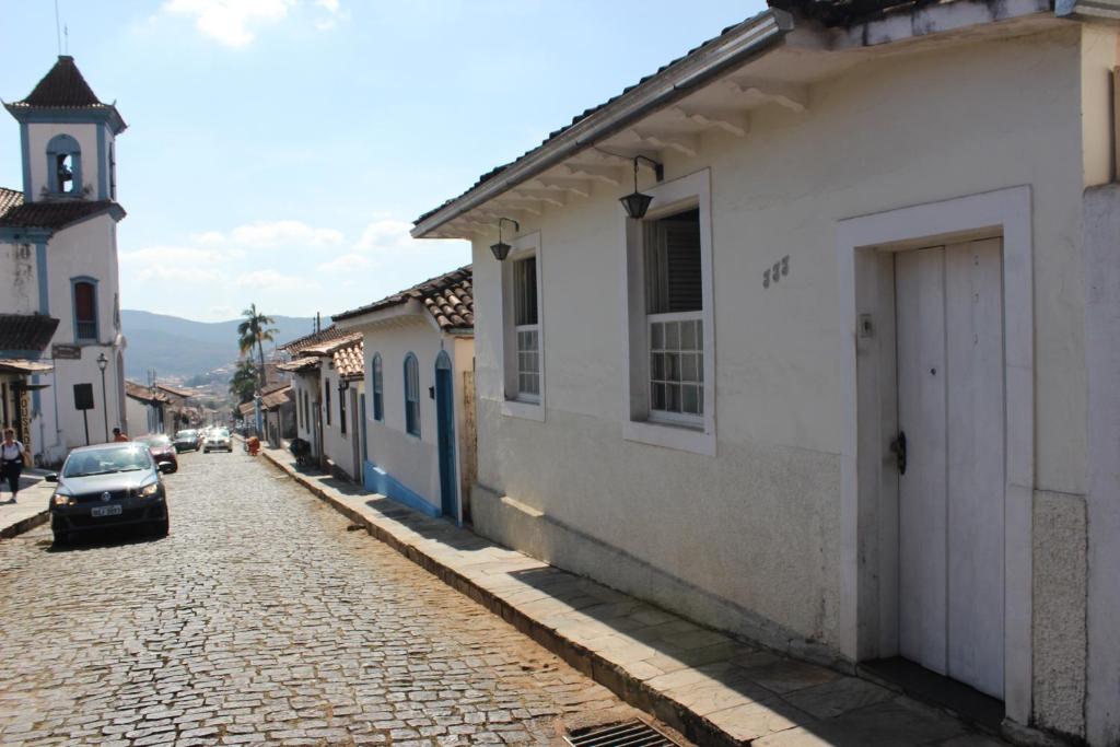 a cobblestone street with a car parked next to a building at Aconchego da Helo in Mariana