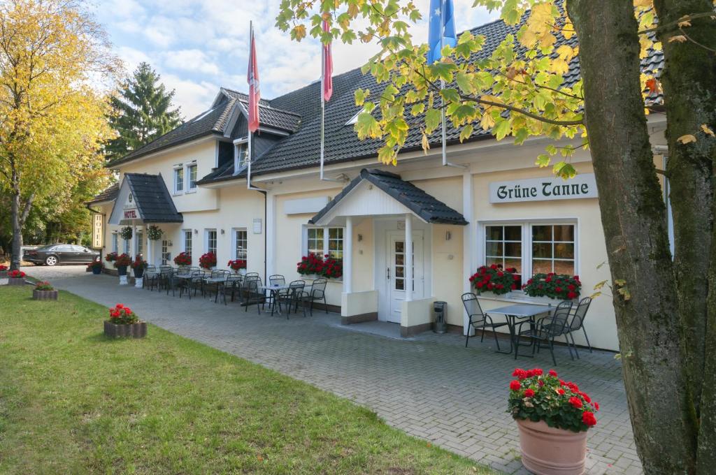 ein Gebäude mit Tischen und Stühlen davor in der Unterkunft Hotel Grüne Tanne in Hamburg