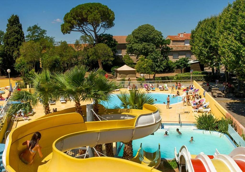 uma piscina num resort com pessoas em Mobile Home tout confort Séléna em Agde