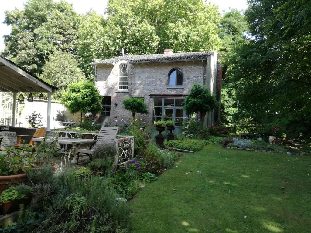 un jardín frente a una casa de piedra en Eremyten Hof en Evergem