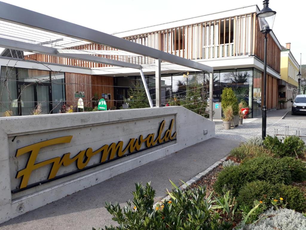 a building with a sign on the side of it at Hubertushof Fromwald Hotel und Gasthof in Bad Fischau