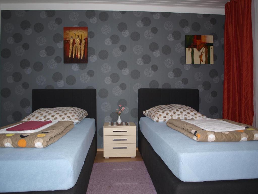 a bedroom with two twin beds and a wall at Stadtrand Hotel in Hagen
