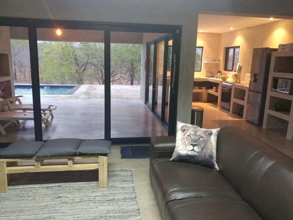 a living room with a couch with a lion pillow at Lionsview Private Lodge - 6 Lions in Marloth Park