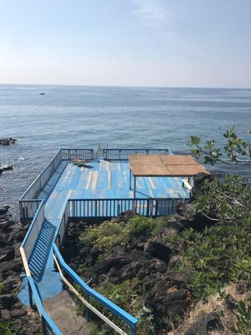 un edificio en lo alto de un acantilado cerca del océano en La Lampara Apartment en Aci Castello