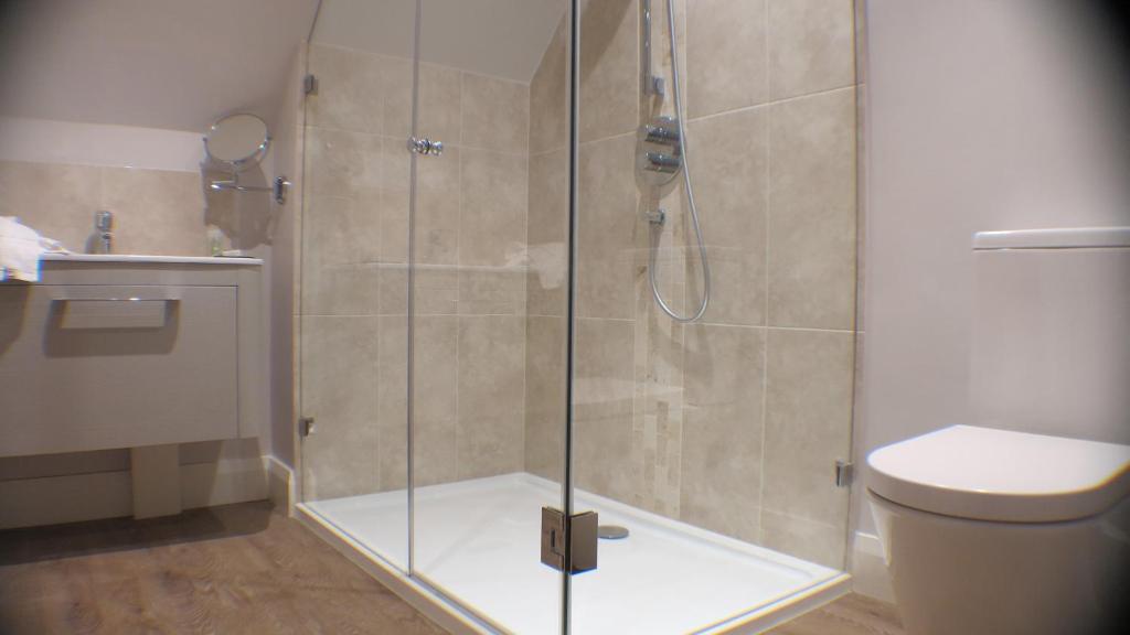 a shower with a glass door in a bathroom at White Hart Hotel in Dorchester on Thames