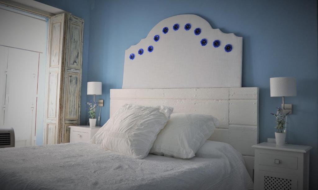 サンルーカル・デ・バラメダにあるCasa de Luzのベッドルーム1室(青い壁の白いベッド1台付)
