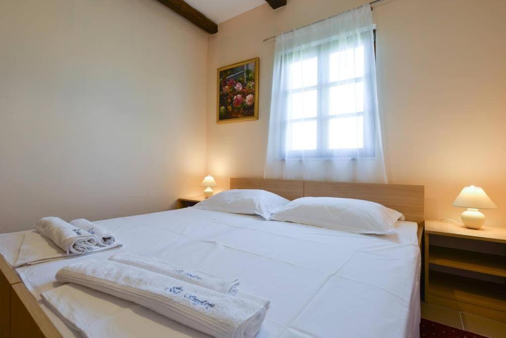 sypialnia z białym łóżkiem i oknem w obiekcie Villa Steffany Apartments w mieście Kolan