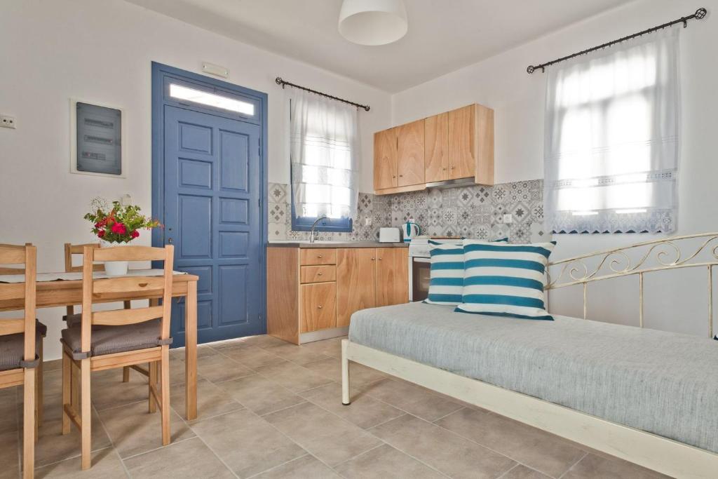 a bedroom with a bed and a table and a kitchen at Alisachni Villas in Lefkos Karpathou