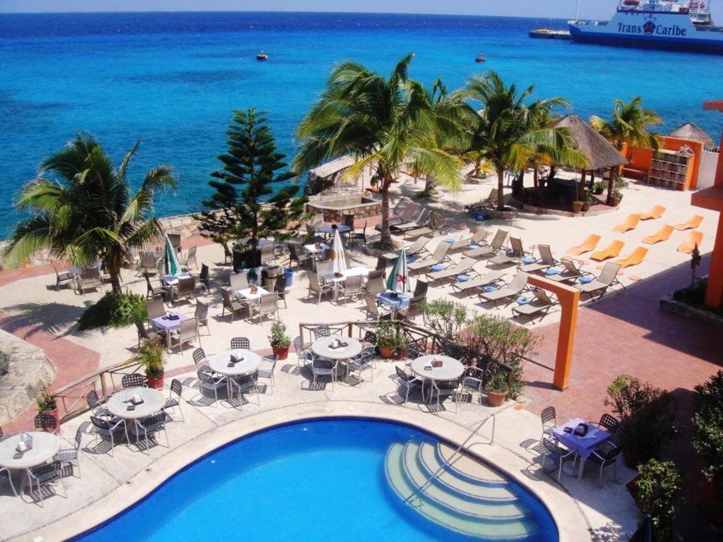 a view of a resort with a swimming pool and the ocean at Hotel Barracuda in Cozumel