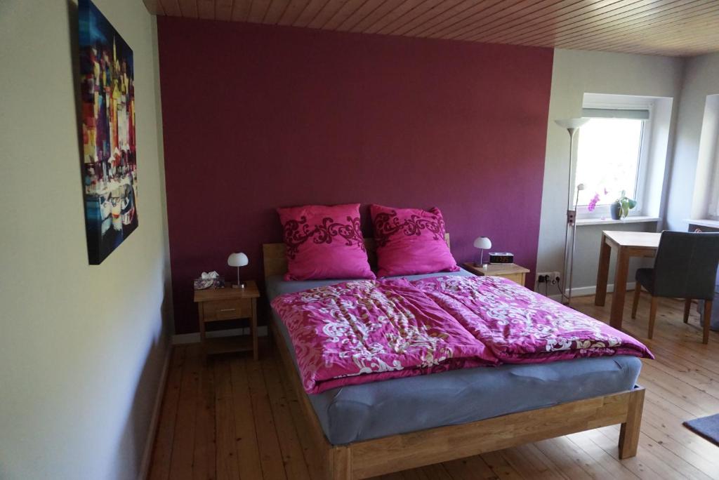 1 dormitorio con 1 cama con manta rosa en Grüne Oase, en Hargesheim