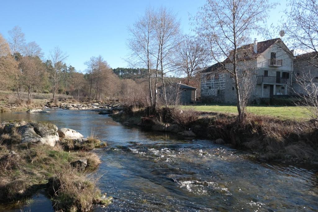 una vecchia casa vicino a un fiume di fronte a una casa di Casas do Trabulo a Decermilo