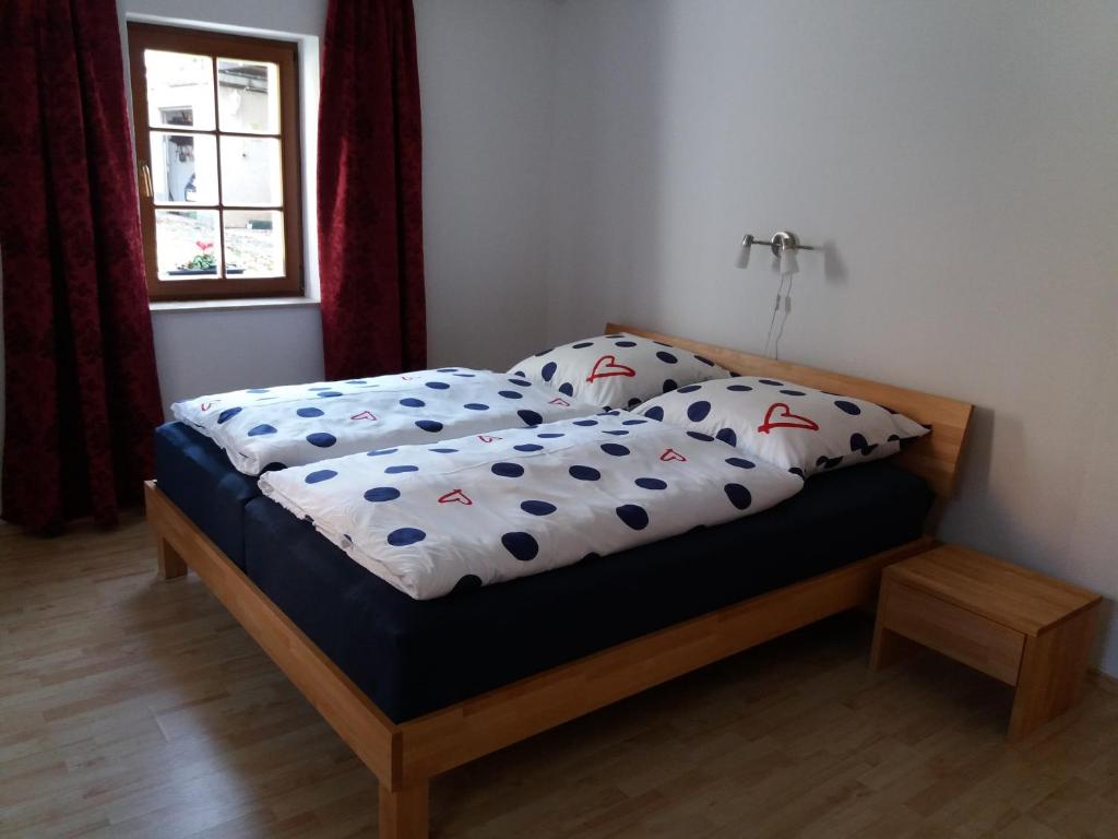 um quarto com uma cama com um edredão e uma janela em Ferienwohnung Wolf em Oberschöna