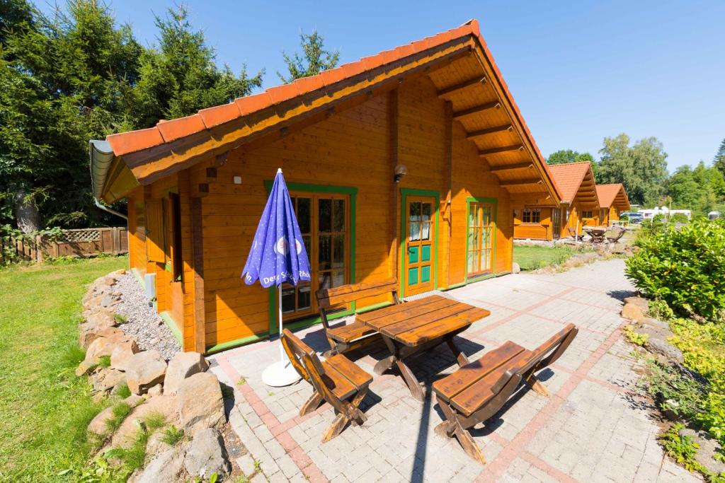 a small cabin with a picnic table and an umbrella at Hotel Grünes Paradies in Hochwaldhausen