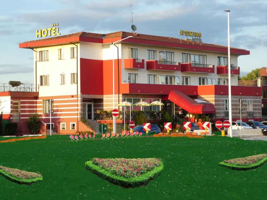 un hotel con césped verde frente a un edificio en Hotel Sporting, en Casarsa della Delizia