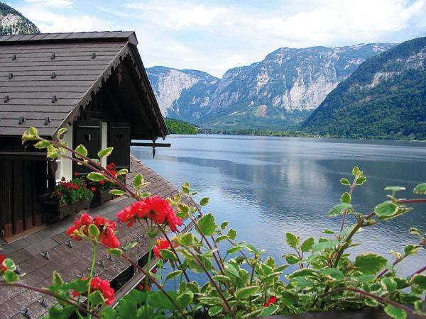 a building with a view of a lake and mountains at Appartement Fallnhauser - Adults only in Hallstatt