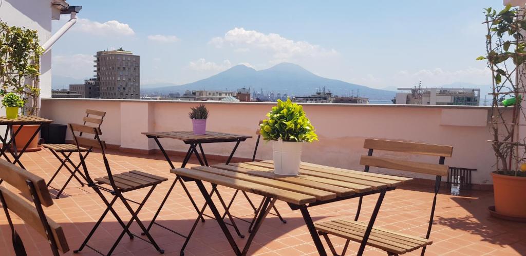 a patio with tables and chairs on a roof at "Panoramic Terrazza - Napoli" in Naples