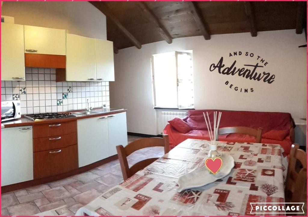 a kitchen with a table with a heart on the wall at Fere Du Muin Rosso - Red Apartment in Albisola Superiore