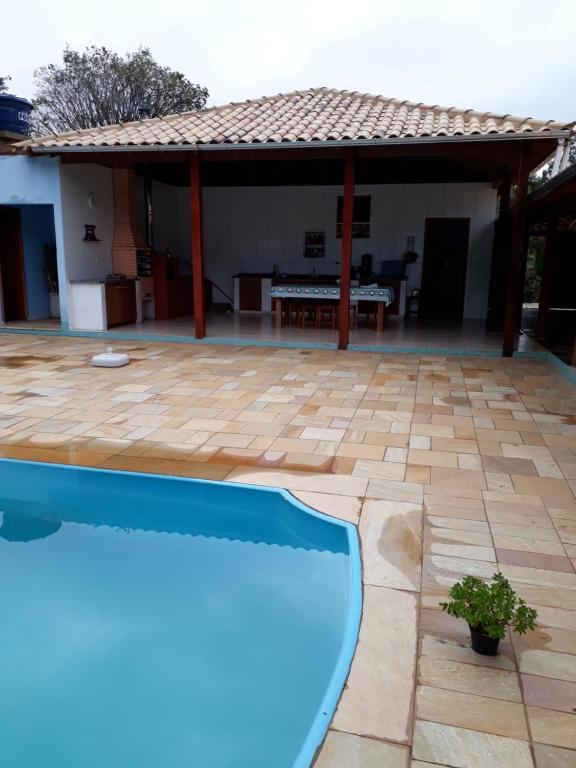 a patio with a swimming pool in front of a house at Casa em São Tomé das Letras in São Thomé das Letras