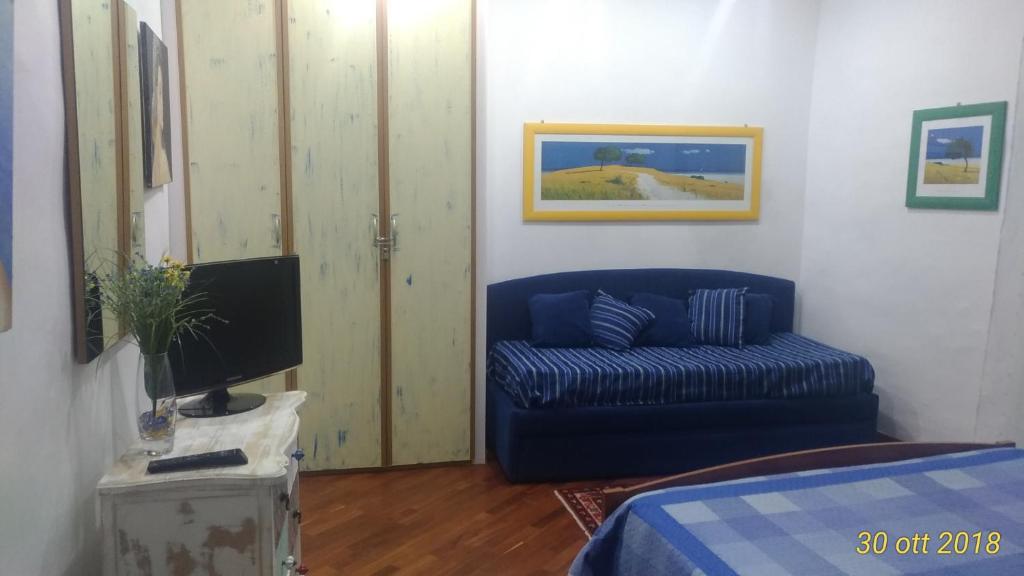 a living room with a blue couch and a tv at Albergo Diffuso Culturart House in Agrigento