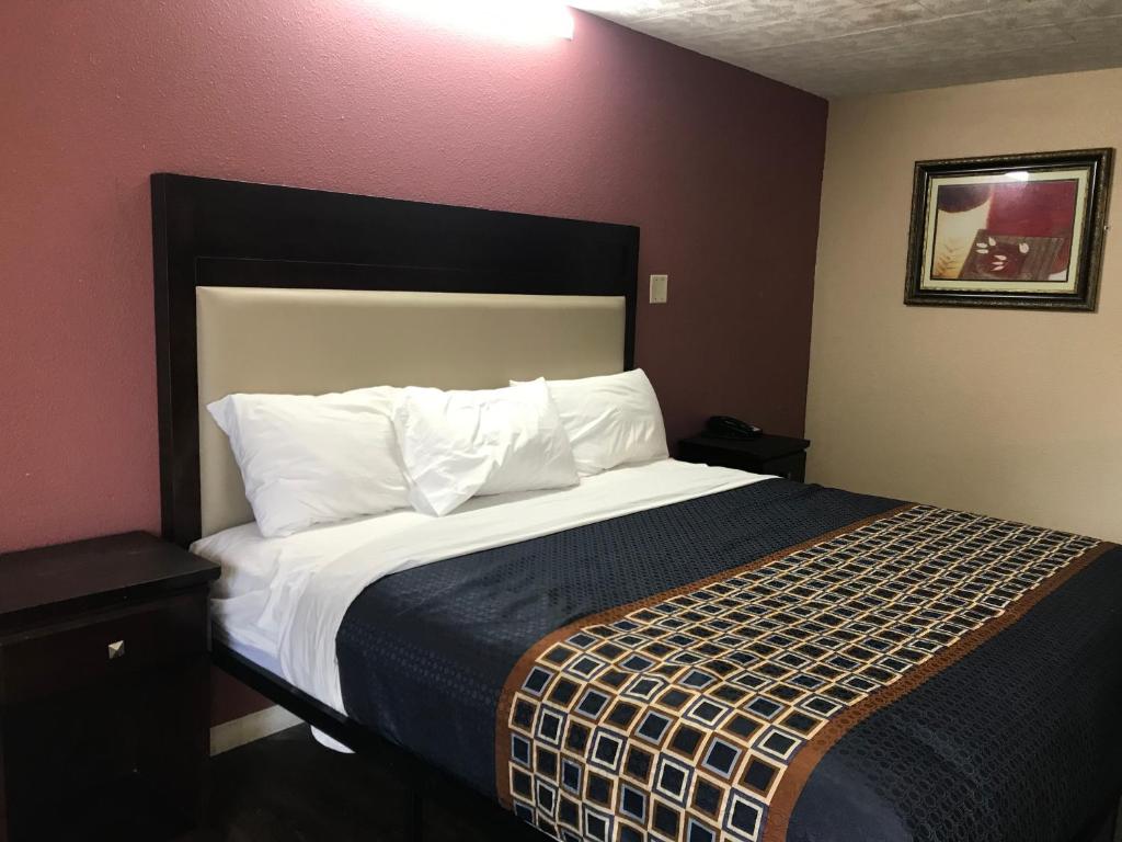 a bedroom with a bed with a black and white comforter at Express Inn in Lafayette