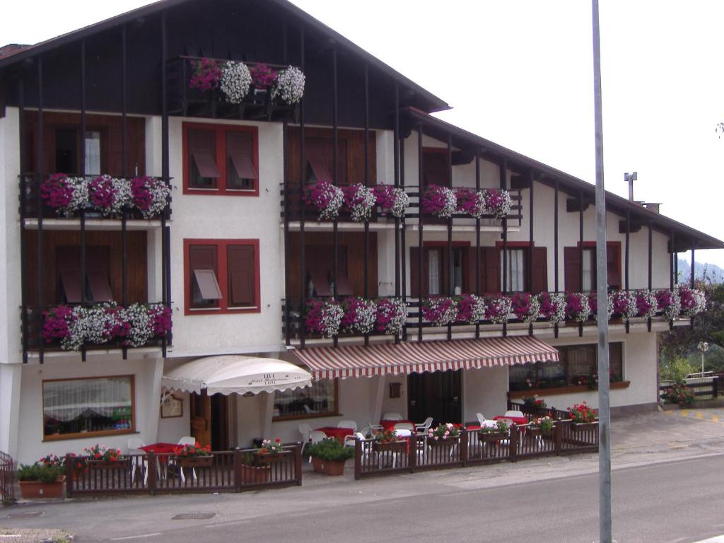 a building with flowers on the balconies and tables at Residence Hotel Montechiara in Baselga di Pinè