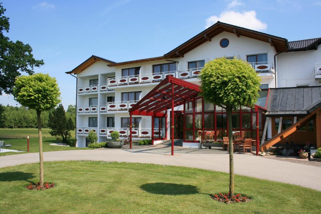 ein Hotel mit zwei Bäumen davor in der Unterkunft Hotel Pension Fent in Bad Füssing