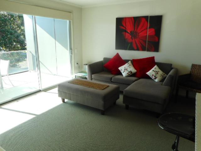 a living room with a couch and a chair at Apartment by the Marina in Whitianga