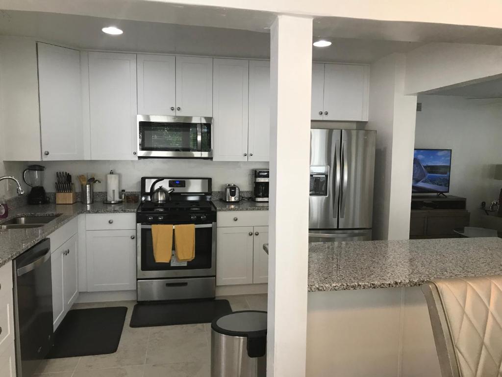 uma cozinha com armários brancos e um fogão em Pine Street em Clearwater
