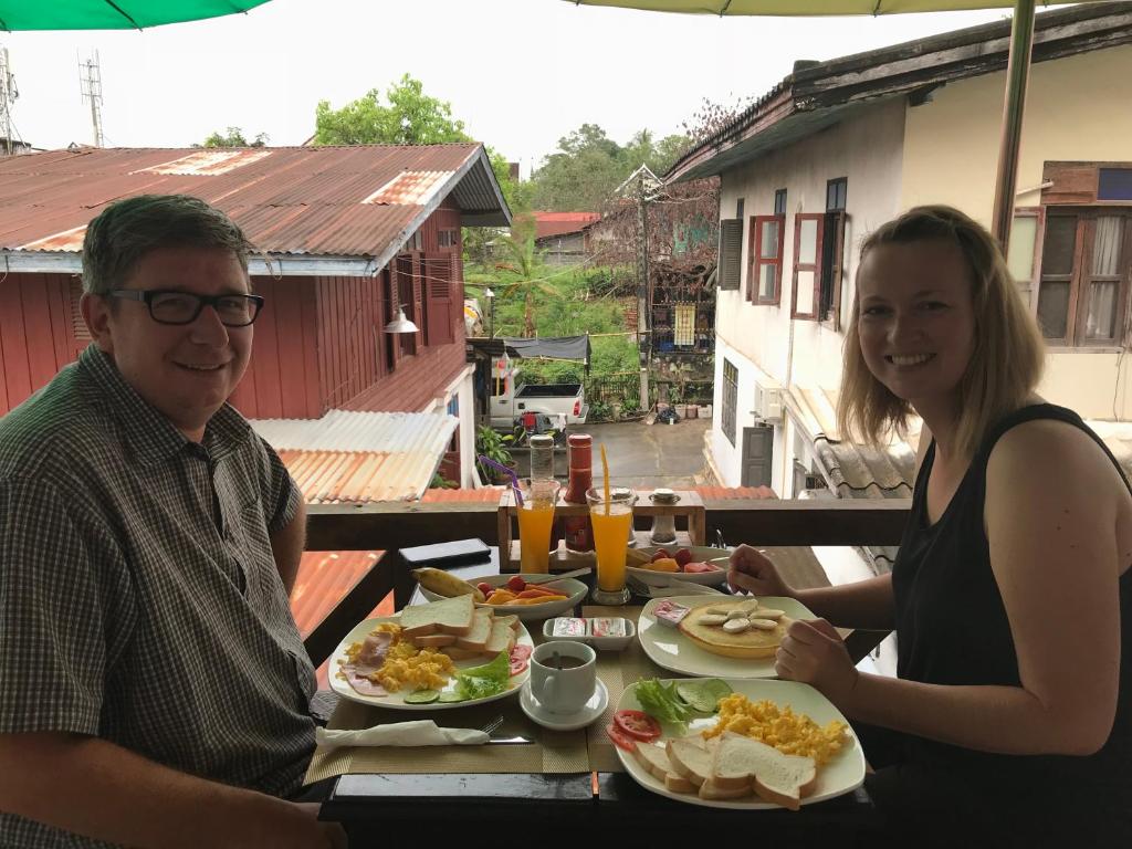 Un hombre y una mujer sentados en una mesa con comida. en Liberty Place, en Luang Prabang