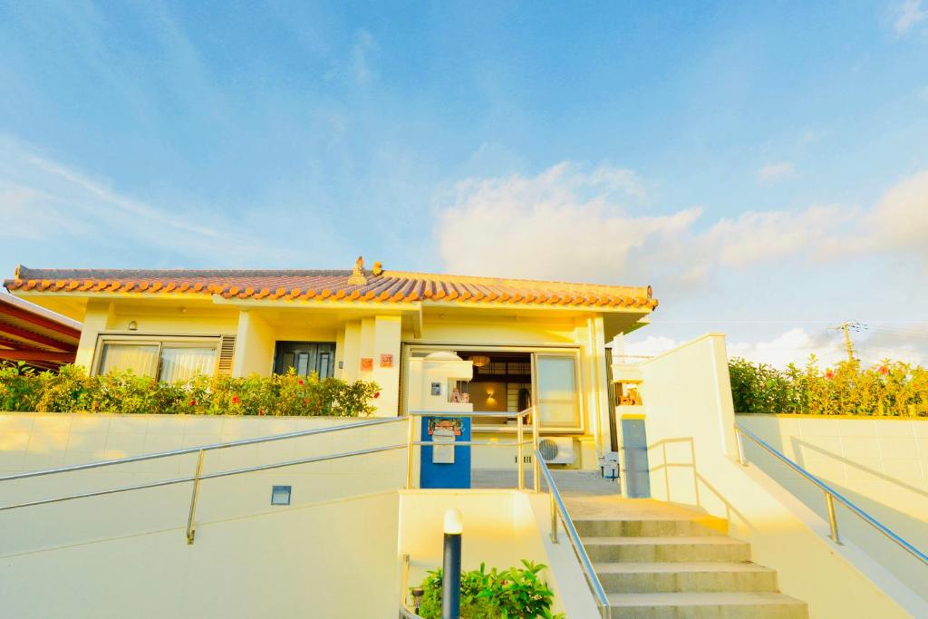 a house with stairs leading to the front door at ゆい屋 in Ishigaki Island