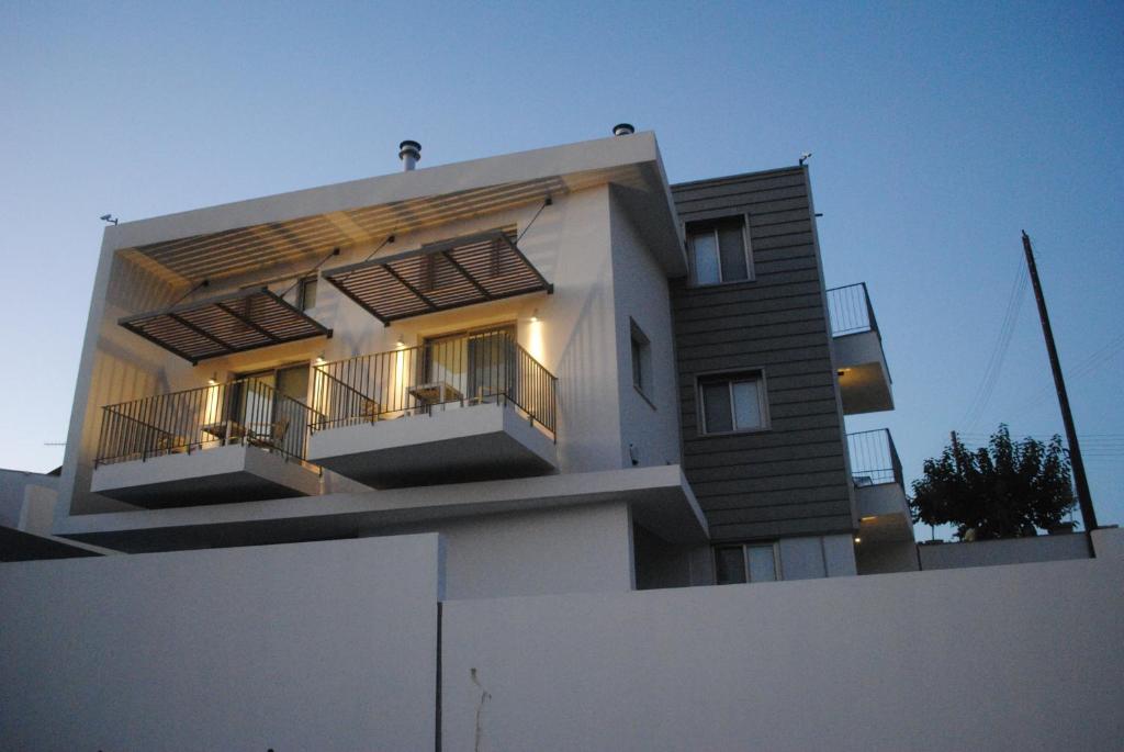 a white building with balconies on top of a fence at Agnanti Apartments in Argaka