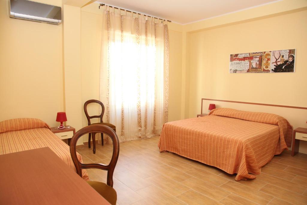 雷焦卡拉布里亞的住宿－Bed And Coffee，酒店客房设有两张床和窗户。