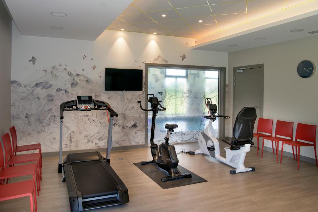 een fitnessruimte met loopbanden en fitnessapparatuur in een kamer bij Domitys L'organdi in Kingersheim