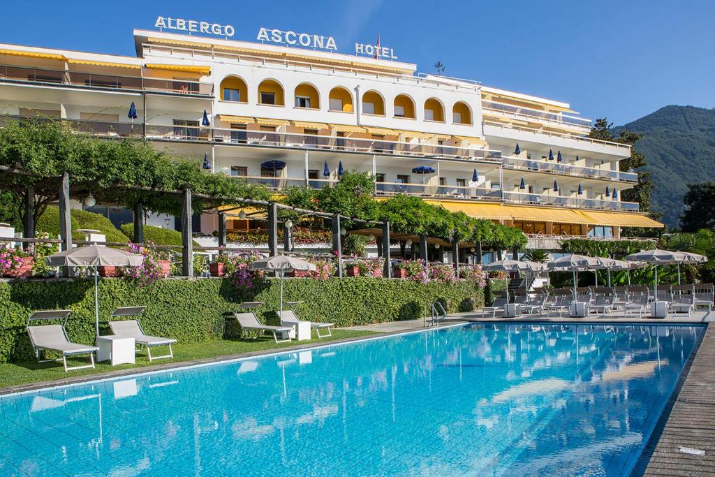 a large swimming pool in front of a large building at Hotel Ascona in Ascona