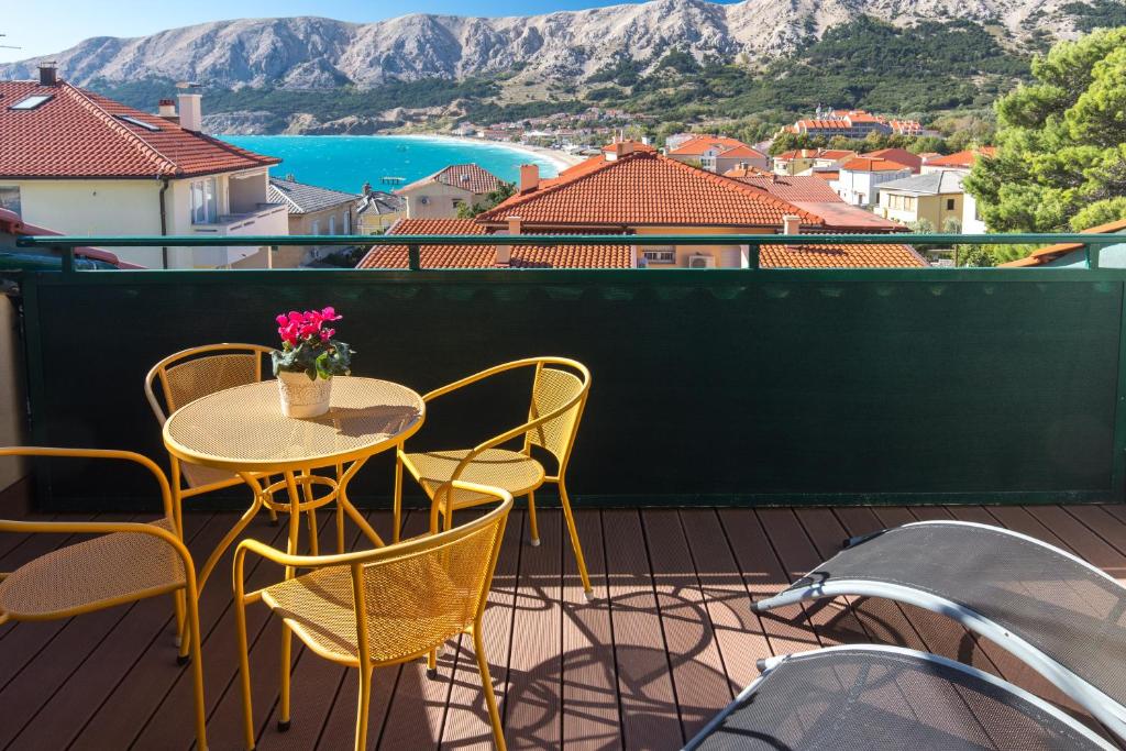 a table and chairs on a balcony with a view at Apartments DDD in Baška
