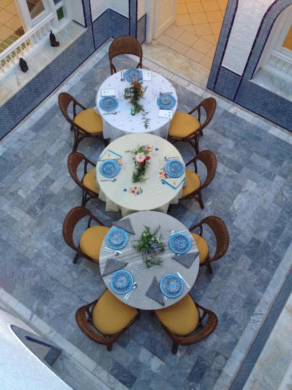 a group of tables and chairs with flowers on them at Villa Phoenicia in Hammamet