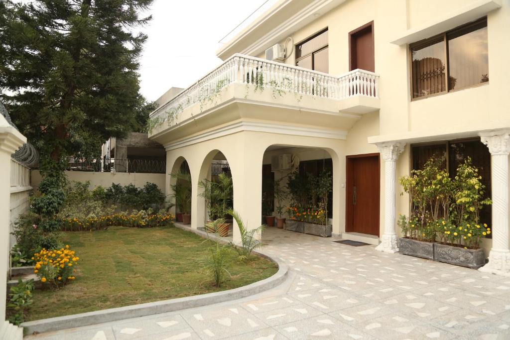 a white house with a courtyard and a balcony at Royal Grace Guest House in Islamabad
