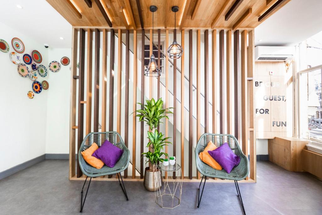 2 Stühle mit Kissen in einem Zimmer mit Holzwänden in der Unterkunft Hotel Pagi in Amsterdam