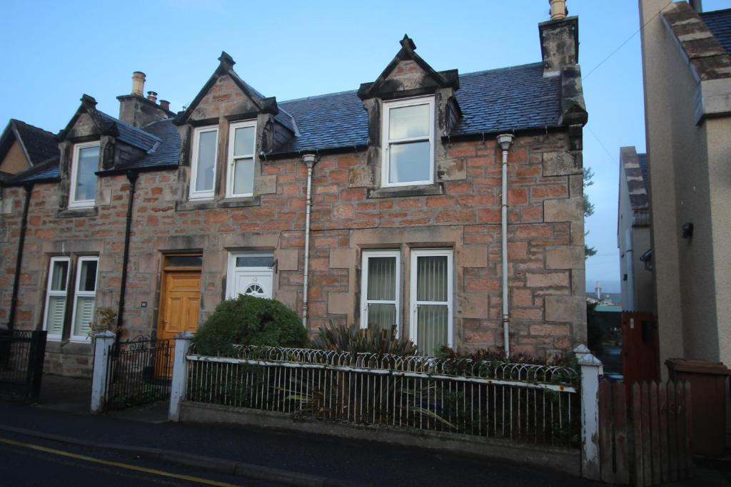 een stenen huis met een hek ervoor bij 63 Argyle Street in Inverness