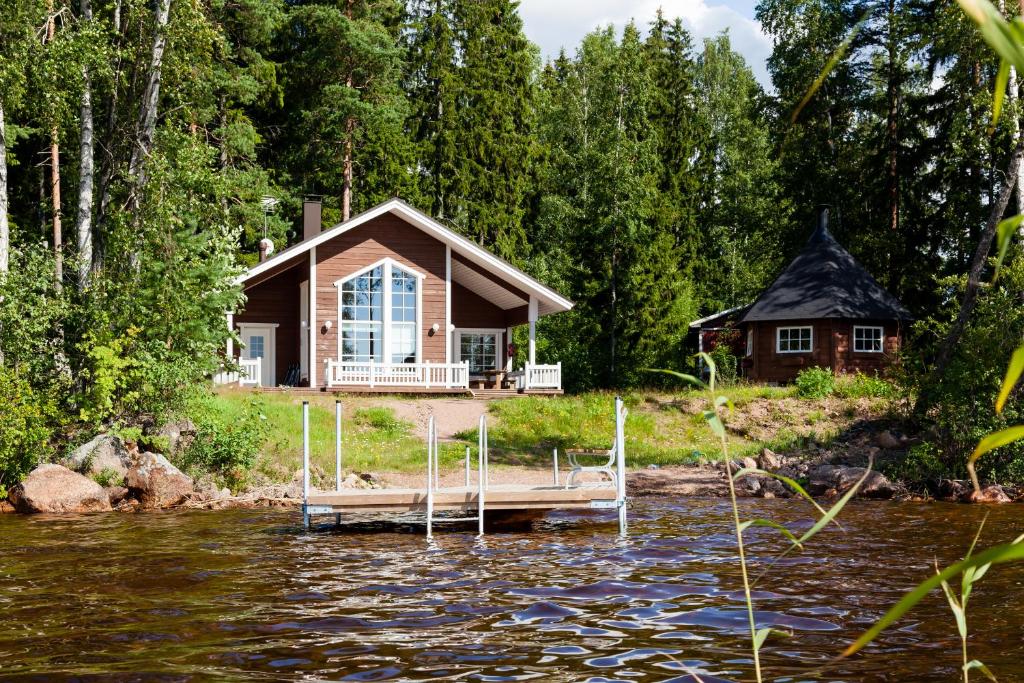 a cabin on the river with a dock in the water at Kotoranta in Kouvola